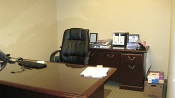 The office before re-design: bare desk, cluttered shelf, empty walls